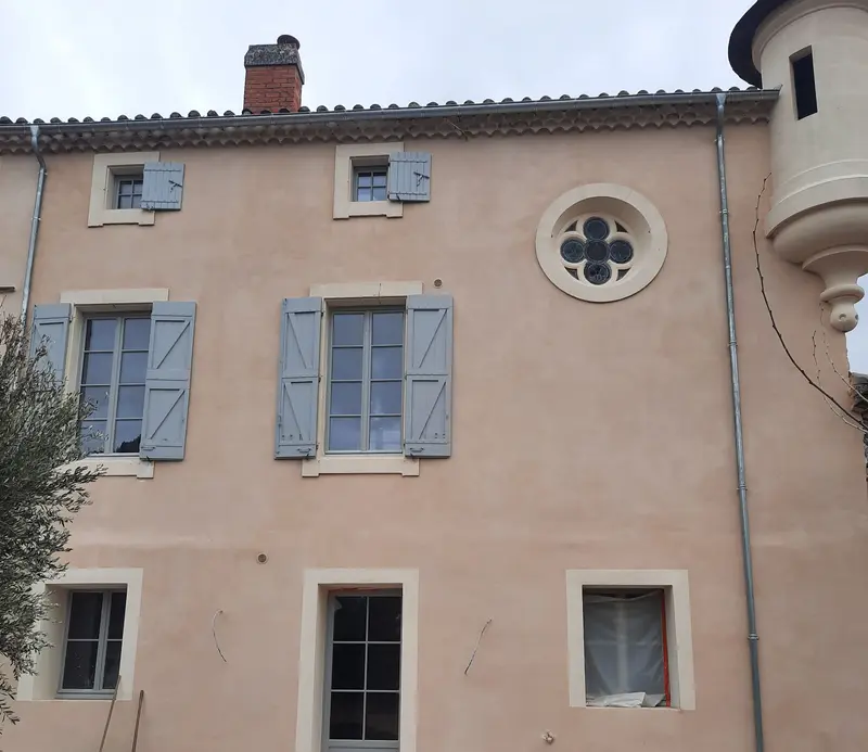 Façade du château de Pézenas après l'enduit à la chaux ton rosé, oculus et tourelle